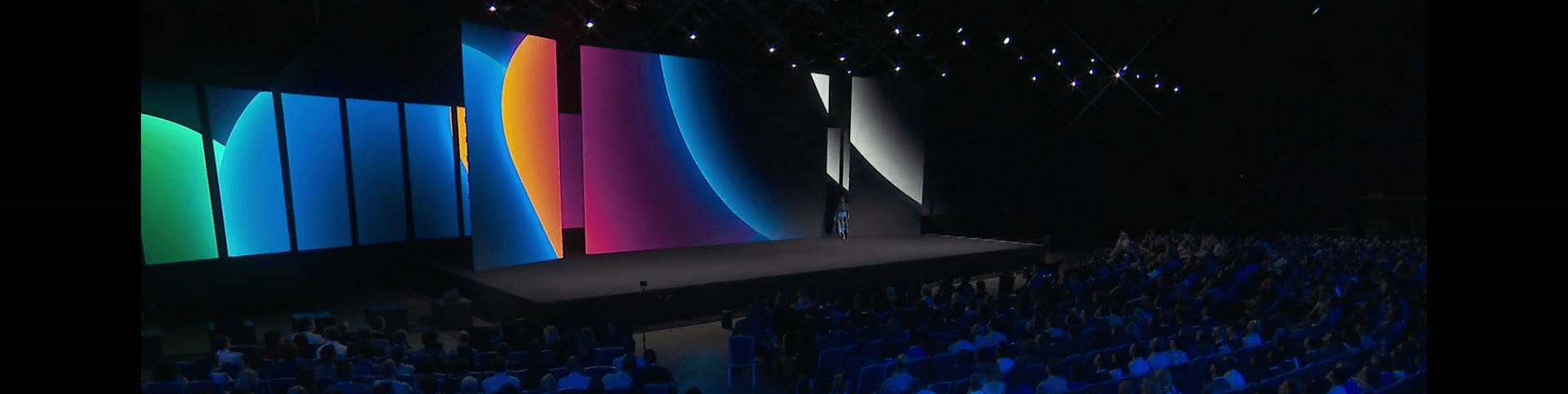 Keynote stage with large-format LED walls in front of a seated audience